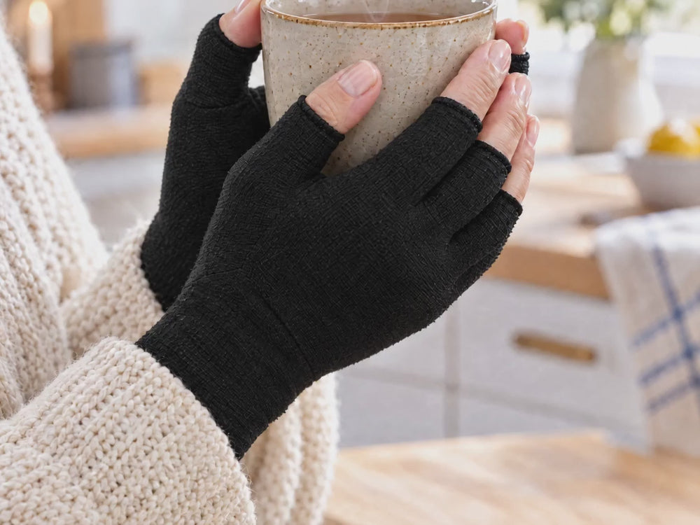 Händer i svarta kompressionshandskar runt en varm kaffekopp